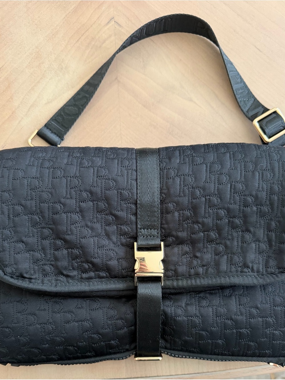 Posh Peanut Black Quilted Messenger Bag with Gold Buckle changing mat
